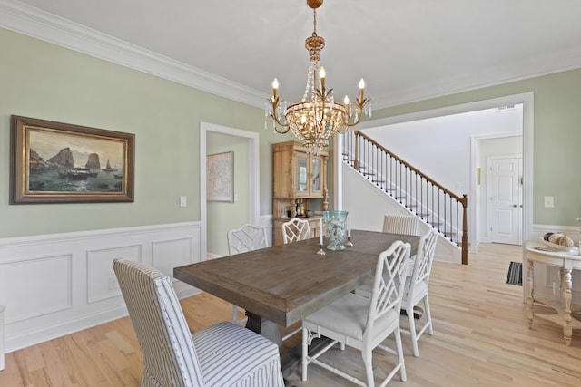 1216 Rivers Reach Dr, Charleston, SC 29492 - dining room with a chandelier, crown molding, light wood-type flooring, wainscoting, and a decorative wall