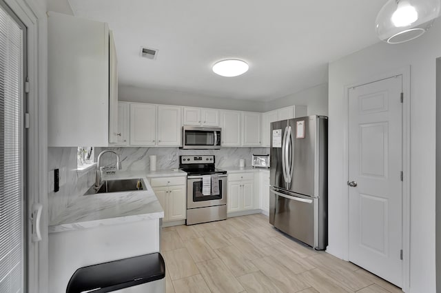 7838 Long Shadow Ln, North Charleston, SC 29406 - kitchen with appliances with stainless steel finishes, a sink, tasteful backsplash, and white cabinetry