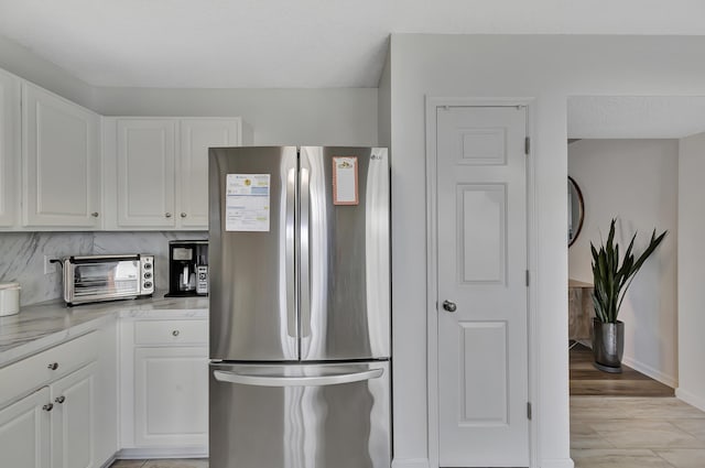 7838 Long Shadow Ln, North Charleston, SC 29406 - kitchen with freestanding refrigerator, white cabinetry, light countertops, and baseboards