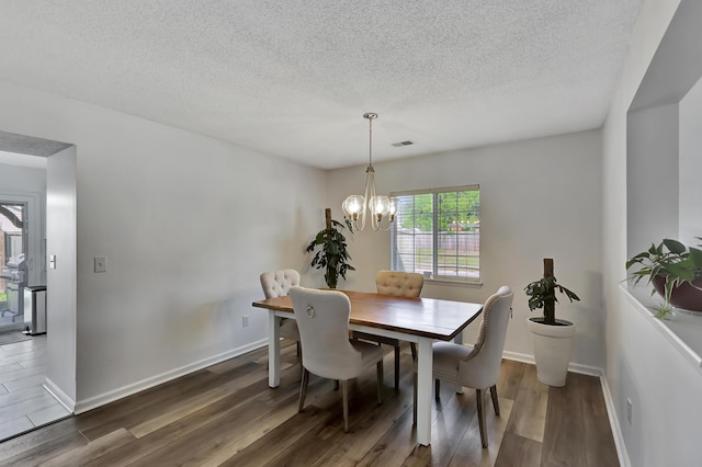 7838 Long Shadow Ln, North Charleston, SC 29406 - dining space featuring wood finished floors, a chandelier, a textured ceiling, and baseboards
