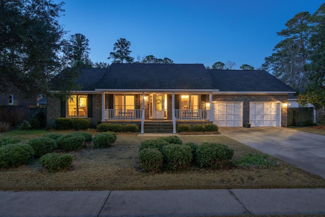 single story home featuring a garage, a porch, concrete driveway, and brick siding