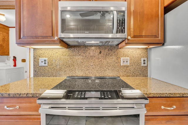 kitchen with appliances with stainless steel finishes, brown cabinetry, independent washer and dryer, and tasteful backsplash