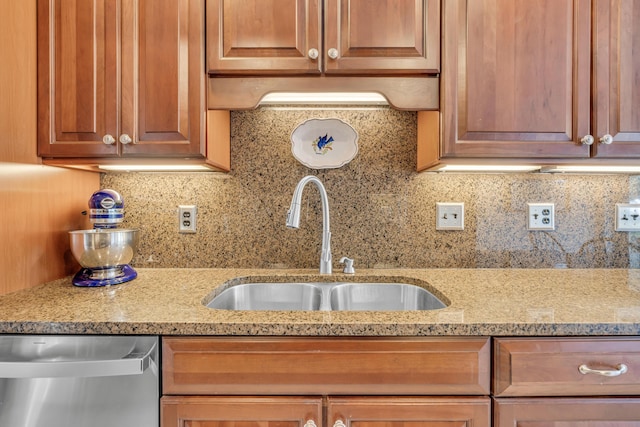 kitchen with a sink, light stone countertops, tasteful backsplash, and stainless steel dishwasher