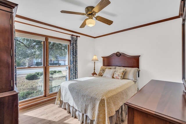 bedroom with ornamental molding, ceiling fan, and wood finished floors