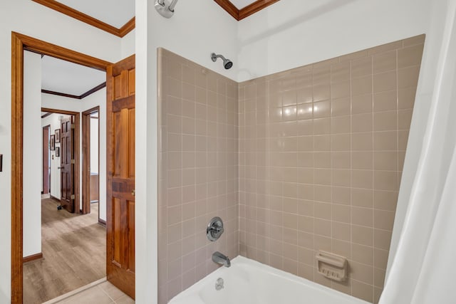 bathroom with wood finished floors, crown molding, baseboards, and shower / bath combo with shower curtain