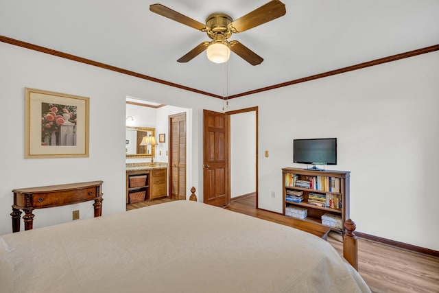 bedroom featuring ensuite bath, baseboards, ornamental molding, and wood finished floors