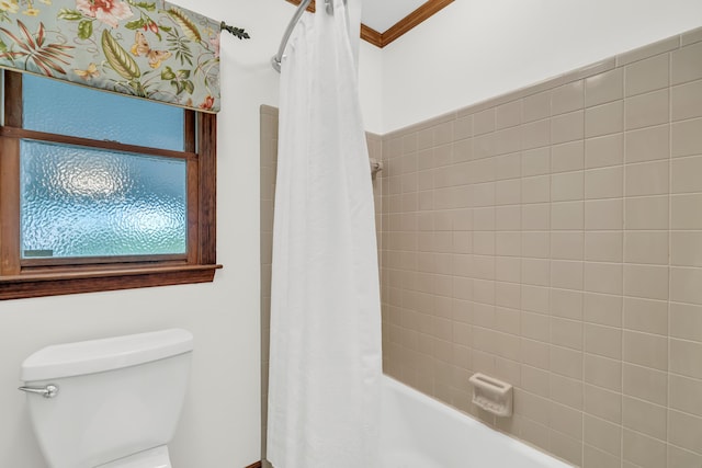 bathroom with ornamental molding, toilet, and shower / bath combo with shower curtain