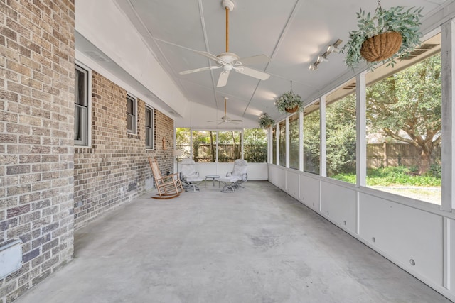 unfurnished sunroom featuring plenty of natural light, vaulted ceiling, and a ceiling fan