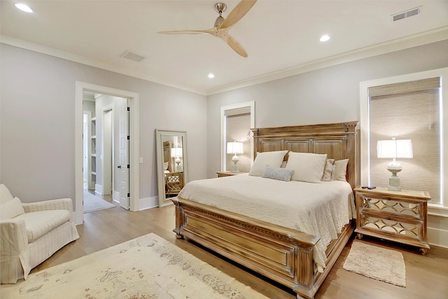 bedroom with ceiling fan, ornamental molding, and light hardwood / wood-style floors