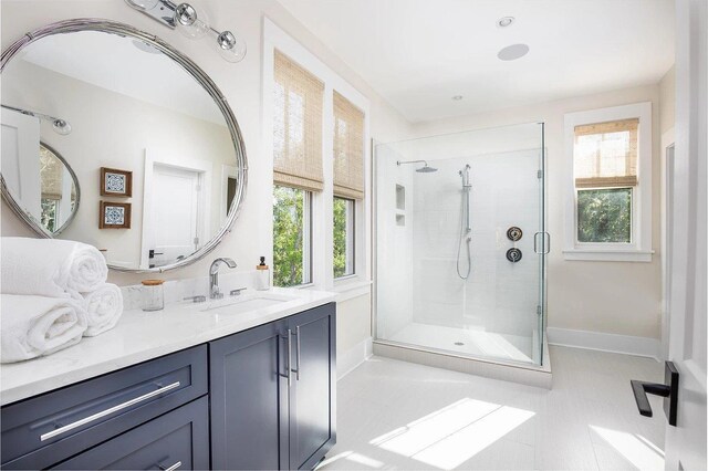 bathroom with tile patterned floors, vanity, and a shower with door