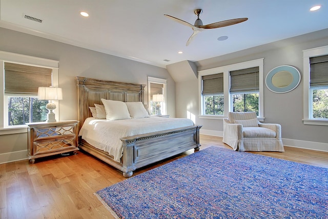 bedroom with ceiling fan, light hardwood / wood-style flooring, and multiple windows