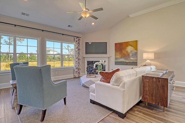living area featuring wood finished floors, baseboards, ceiling fan, lofted ceiling, and a premium fireplace