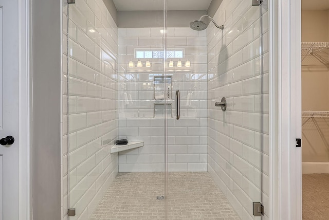 bathroom with a shower stall and a spacious closet