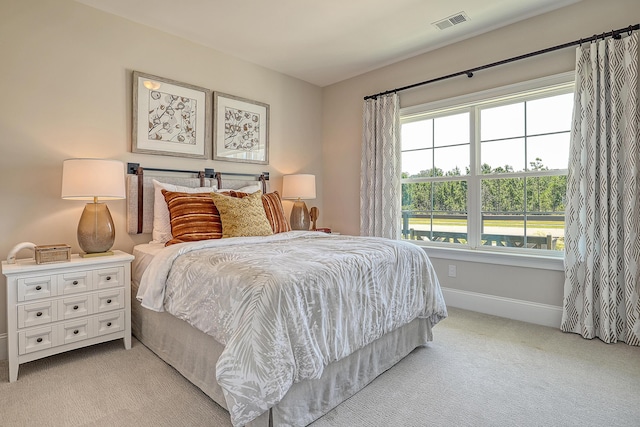 bedroom with light colored carpet and baseboards