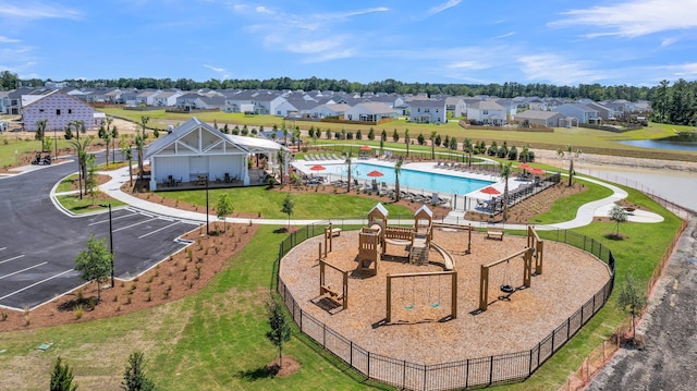 aerial view of residential area featuring a pool area and a nearby body of water