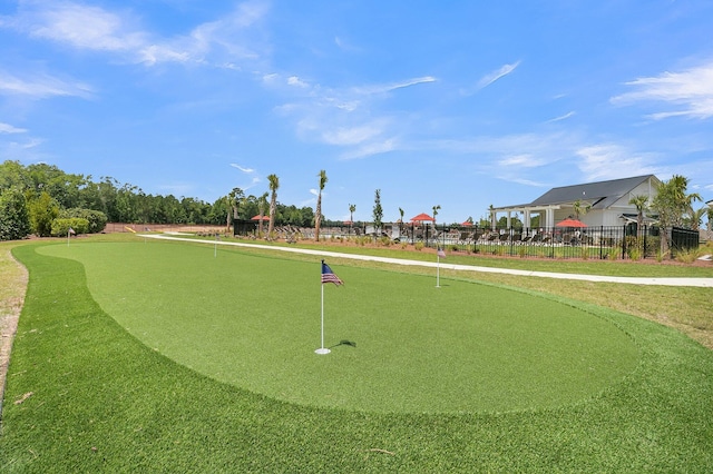 view of home's community featuring fence and a putting area