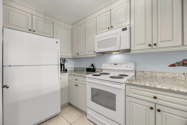 kitchen with light stone counters, light tile patterned floors, and white appliances