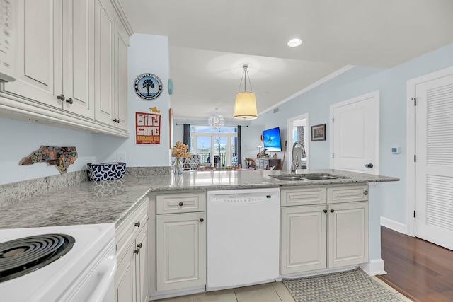 kitchen featuring white dishwasher, sink, white cabinetry, and kitchen peninsula