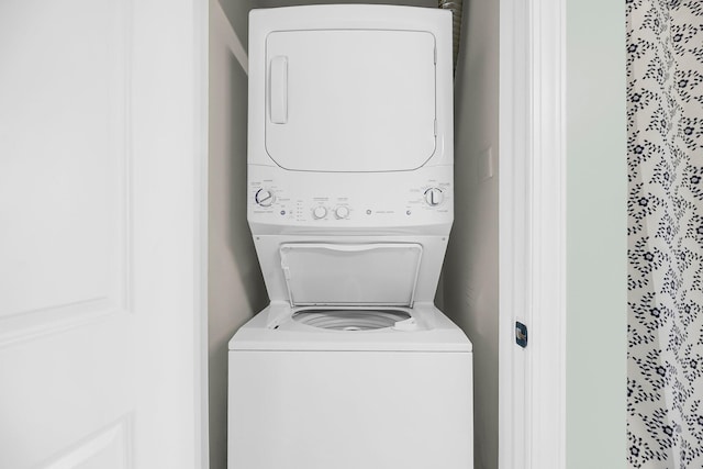 clothes washing area featuring stacked washer / dryer