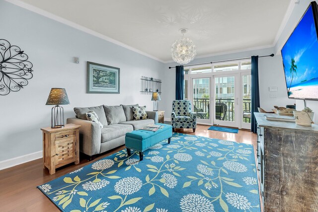 living room featuring ornamental molding, hardwood / wood-style flooring, and a chandelier