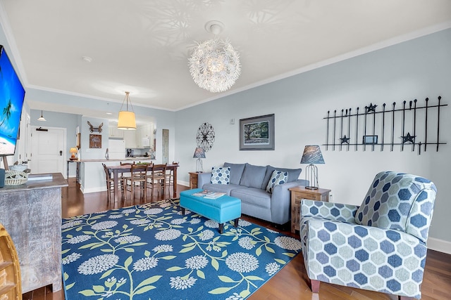 living room with ornamental molding, dark hardwood / wood-style floors, and an inviting chandelier