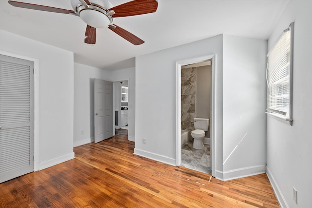 unfurnished bedroom featuring a closet, ensuite bathroom, light hardwood / wood-style flooring, and ceiling fan