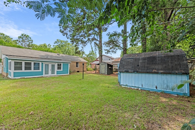 view of yard featuring french doors and a storage shed