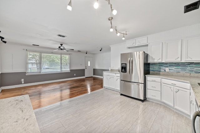 kitchen featuring ceiling fan, light tile patterned floors, stainless steel fridge with ice dispenser, decorative backsplash, and white cabinets