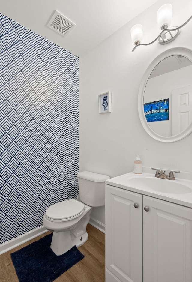 bathroom featuring vanity, hardwood / wood-style flooring, and toilet