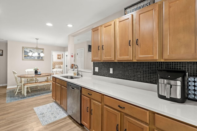 kitchen with dishwasher, sink, hanging light fixtures, light hardwood / wood-style flooring, and tasteful backsplash