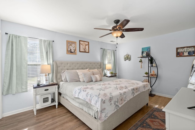 bedroom with multiple windows, ceiling fan, and hardwood / wood-style floors