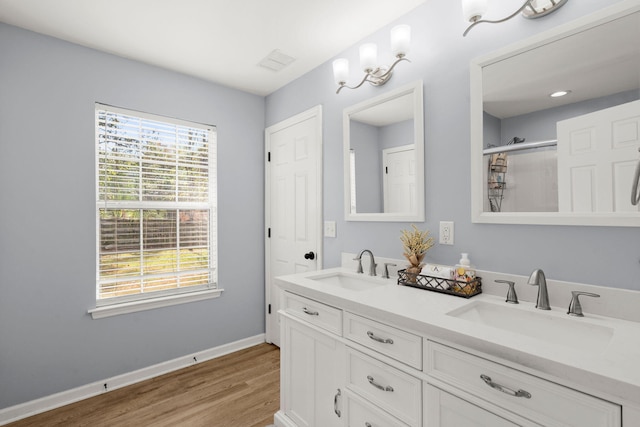 bathroom with hardwood / wood-style floors, vanity, and an enclosed shower