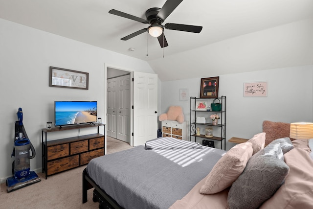 bedroom with ceiling fan, a closet, light carpet, and vaulted ceiling