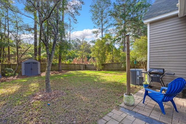 view of yard featuring central AC, a storage shed, and a patio area