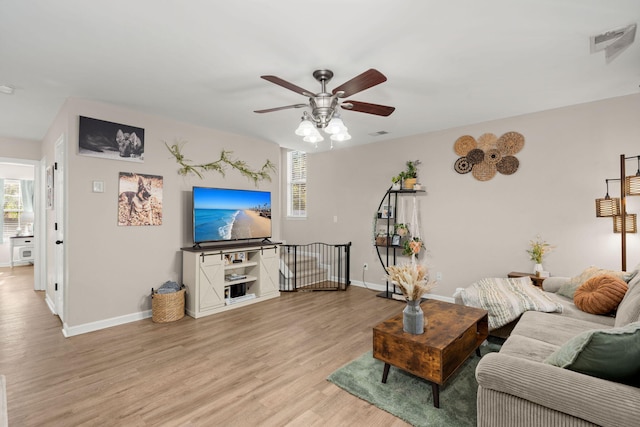 living room featuring light wood-type flooring and ceiling fan