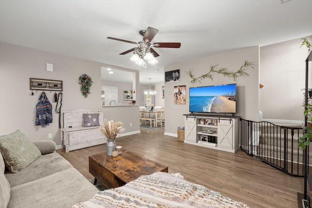 living room featuring hardwood / wood-style floors and ceiling fan with notable chandelier