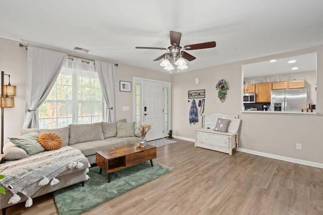 living room featuring ceiling fan and light hardwood / wood-style flooring