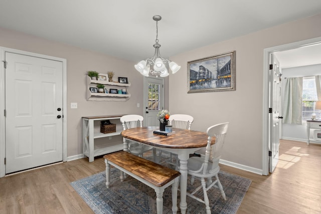 dining area featuring light hardwood / wood-style floors and an inviting chandelier