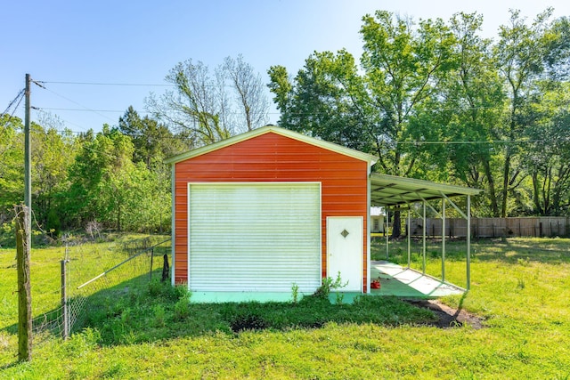 garage with a carport and a yard