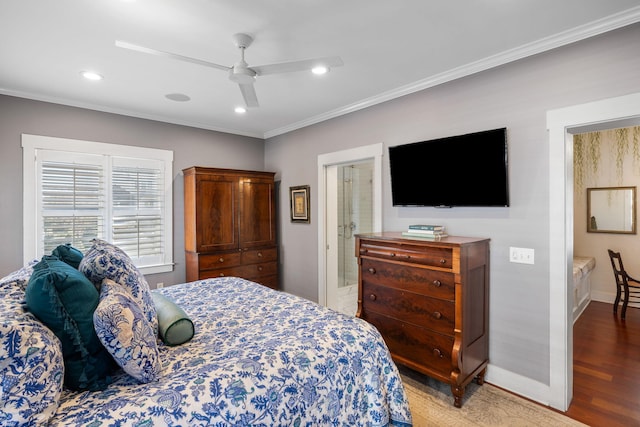 bedroom featuring hardwood / wood-style flooring, ceiling fan, ensuite bathroom, and crown molding