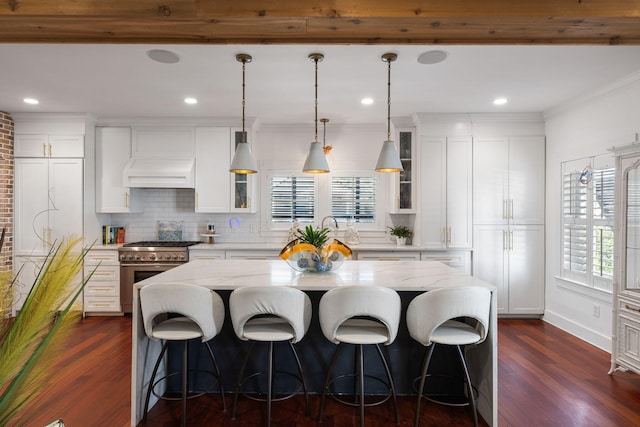 kitchen with white cabinets, a center island, high end range, and dark wood-type flooring