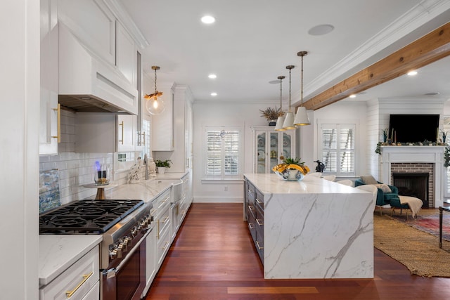 kitchen with stainless steel range, a center island, decorative light fixtures, and white cabinets