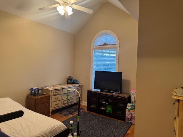 bedroom featuring hardwood / wood-style floors, ceiling fan, and lofted ceiling