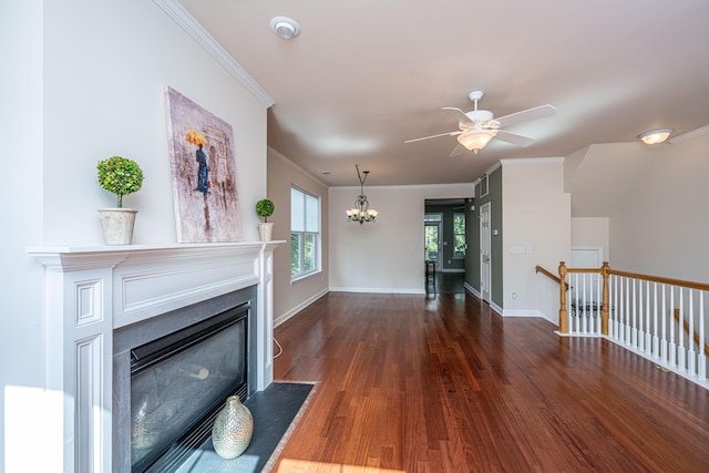 unfurnished living room featuring ceiling fan with notable chandelier, dark hardwood / wood-style floors, and ornamental molding