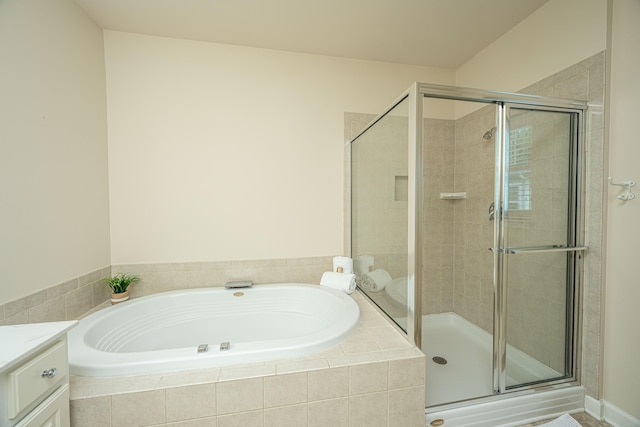 bathroom with vanity and shower with separate bathtub