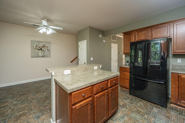 kitchen featuring black fridge, a kitchen island, and ceiling fan