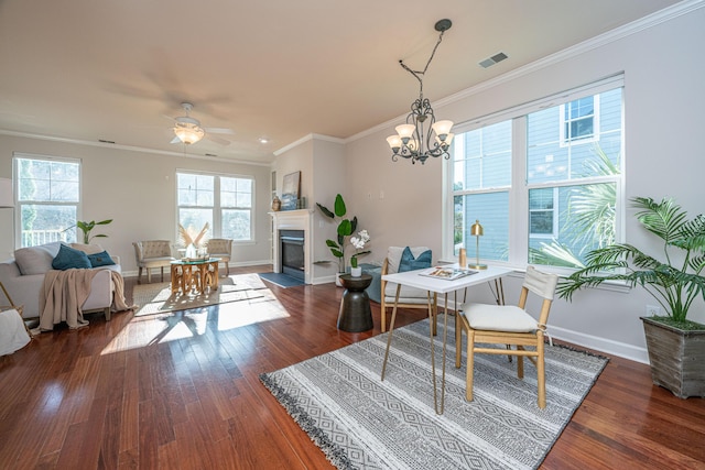 dining room featuring dark hardwood / wood-style flooring, ceiling fan with notable chandelier, and crown molding