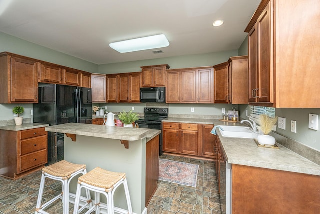 kitchen with sink, a kitchen island, a breakfast bar area, and black appliances