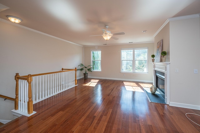 unfurnished living room featuring ceiling fan, ornamental molding, and dark wood-type flooring