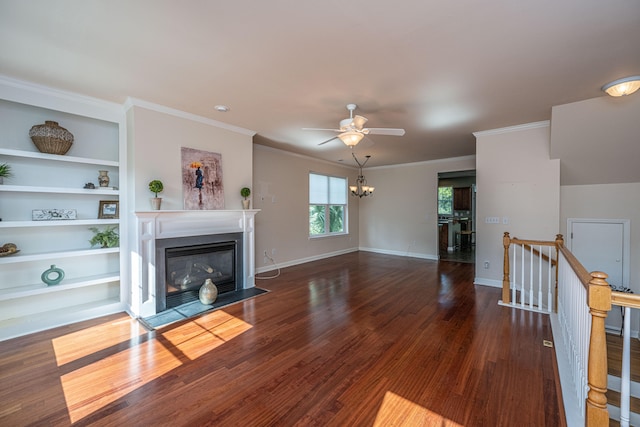 unfurnished living room with dark hardwood / wood-style flooring, crown molding, built in features, and ceiling fan with notable chandelier